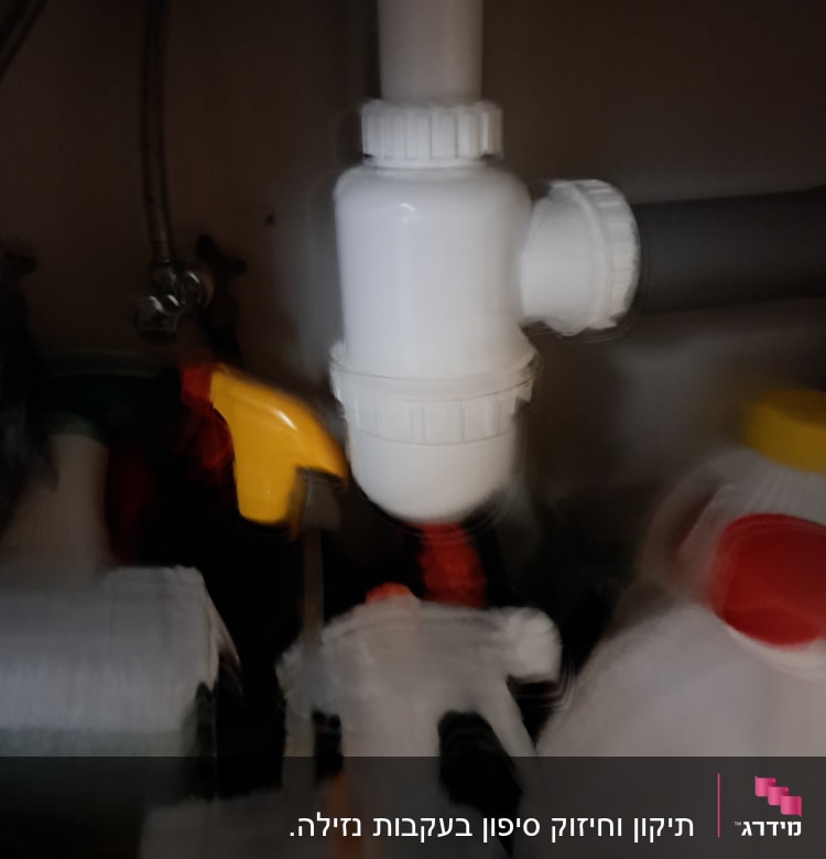 צינור ניקוז לבן מתחת לכיור עם חיבורים